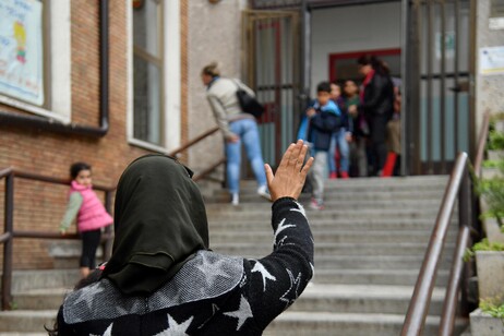 Una madre saluta il figlio all'uscita dalla scuola in una foto d'archivio