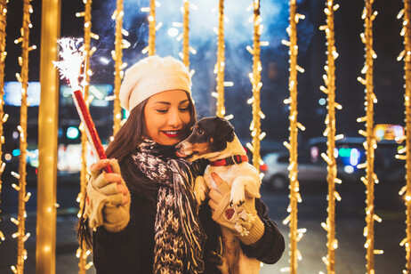 Una giovane donna tiene in braccio il suo cane - foto iStock.