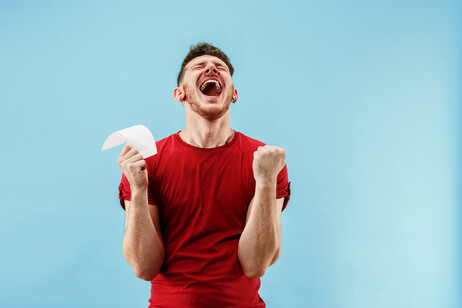 Un ragazzo felice per la vittoria alla lotteria foto iStock.