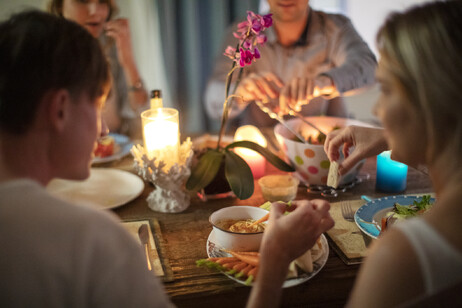 Four friends sitting down for a healthy plant-based dinner.